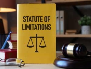 Book titled "Statute of Limitations" with scales of justice, gavel, on a desk.